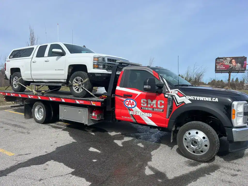 SMC Towing Truck carrying car for towing service in Ottawa